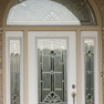 exterior view of a white single entrance door with sidelites and half round transom featuring decorative glass