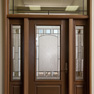 exterior view of wood effect single door with sidelites and transom featuring decorative glass