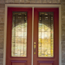 exterior view of red double entrance doors featuring decorative glass