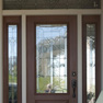 exterior view of wood effect single door with sidelites and transom featuring decorative glass