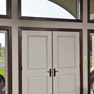 interior view of white double entrance doors with wide sidelites and three shaped transoms