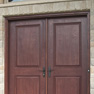 exterior view of dark red stained double entrance doors