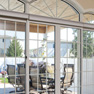 interior view of four panel beige vinyl patio door and shaped transom featuring grills