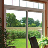 interior living room view of two panel white vinyl patio door with transom featuring grills