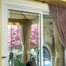 interior dining room view of two panel white vinyl patio door with swagged curtain