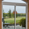 interior recreation room view of two panel white vinyl patio door with knotty pine surround