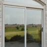 exterior view of two panel beige vinyl patio door on decorative stone patio
