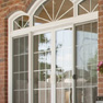 exterior patio view of four panel white vinyl patio doors and shaped transom featuring grills