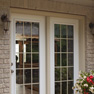 exterior patio view of white vinyl terrace door and matching fixed door with grills