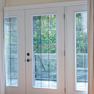 interior bedroom view of white vinyl three panel terrace door featuring grills