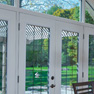 interior dining room view of white vinyl four panel terrace door with grills and shaped transom