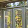 exterior deck view of juniper stained vinyl double terrace door with sidelites and transom featuring grills