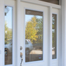 exterior view of a white single entrance door with sidelites and transon
