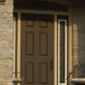 exterior view of a brown single entrance door and sidelites and shaped transom featuring decorative glass