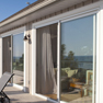 exterior deck view of three white vinyl patio doors on long patio deck