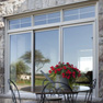 exterior view of beige vinyl three panel patio door behind decorative table and chairs