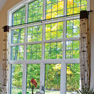 interior living room view of multi panel white vinyl fixed and casement windows with shaped transom featuring grills