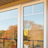 exterior patio view of white vinyl panoramic windows featuring top grill detail