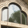 exterior view of shaped espresso stained fixed windows above front door