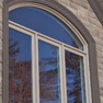 exterior view of three pane ivory stained casement window with shaped transom and pebble stained trim