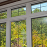 interior dining room view of set of three white vinyl fixed and casement windows featuring grills