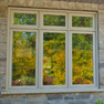 exterior garden view of set of three sandstone stained fixed and casement windows and transom