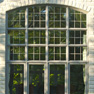 exterior garden view of multi panel clay stained vinyl fixed and casement windows with shaped transom featuring grills