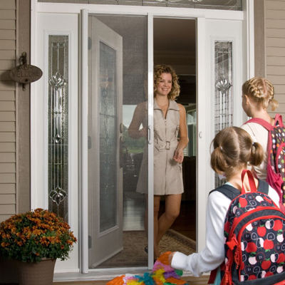 A mother and her two young female children are greeted at the front door