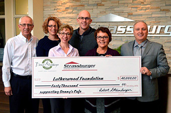 Four members of the Strassburger family present an oversize donation cheque to two representatives of the Lutherwood Foundation